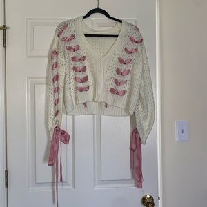 Knit cardigan with intricate pink ribbon detailing
